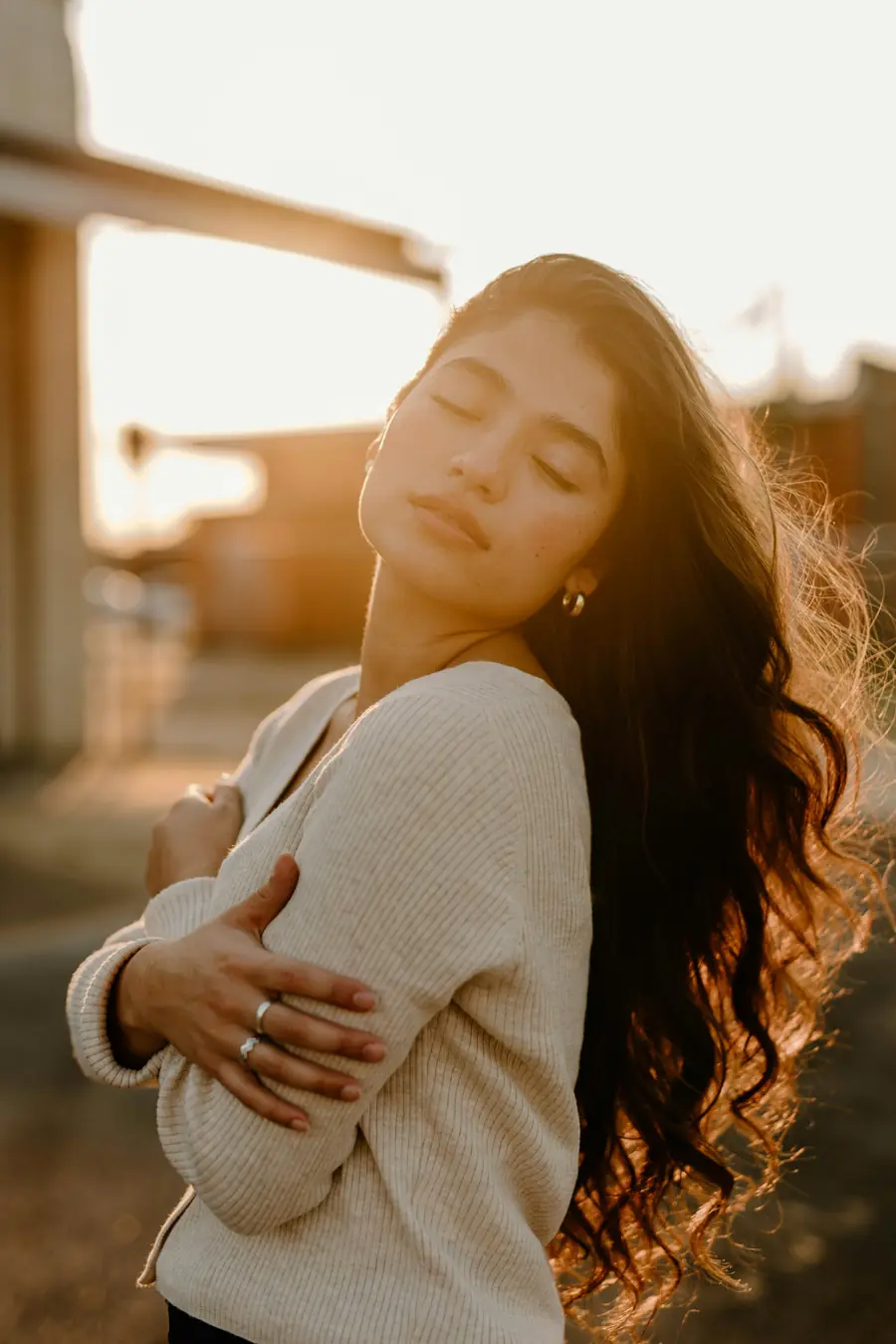 A person breathing easy outdoors with their eyes closed in soft light